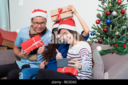 Weihnachtsfeier mit Freunden, asiatische Frau selfie mit lächelnden Gesicht mit Freunden, Urlaub feier Konzept Stockfoto
