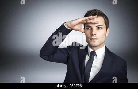 Junge kaukasier Geschäftsmann, der in der Suche pose Studio shot Stockfoto