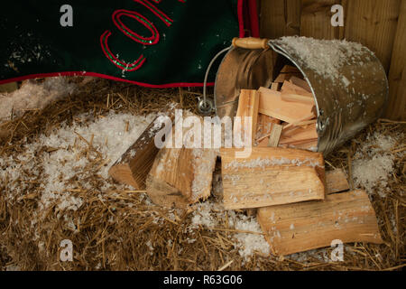 Einen Eimer von Protokollen auf Heu mit Kunstschnee auf die Oberseite, eine Weihnachtsdekoration Szene Stockfoto
