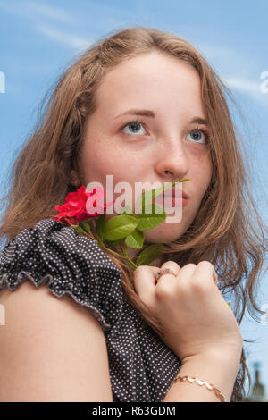 Mädchen mit Rose auf Hintergrund der Himmel Stockfoto