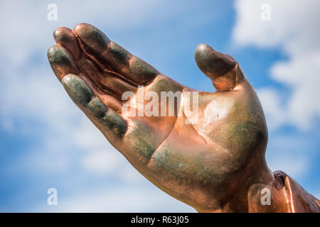 Hand der Bronzestatue gegen den blauen Himmel isoliert Stockfoto