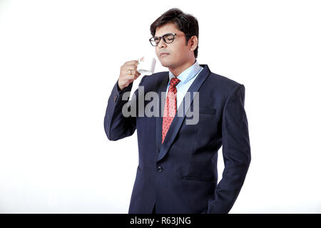 Junge indische Geschäftsmann trinken einen Kaffee auf weißem Hintergrund Stockfoto