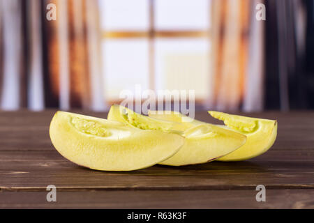 Hinter der Gruppe der drei Scheiben frischen Gestreifte pepino Melone mit seidenen Vorhängen Stockfoto