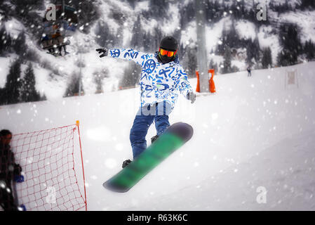 Asiatischer Mann snowboarden auf den verschneiten Berg Stockfoto