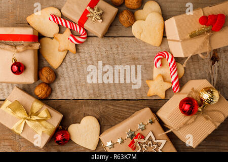 Weihnachten Komposition verschiedener Geschenkboxen in Handwerk eingerichtet rot gold Bänder und Urlaub süße Lebkuchen cookies, Nussbaum, Candy Cane. T Stockfoto