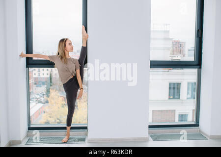 Junge super angenehme sportliche Mädchen lehnte sich an die Wand und stehen auf dem Bein. volle Länge Foto. Kopieren Sie Platz Stockfoto