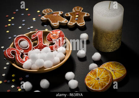 Weihnachtskarte: auf einer Holzplatte Es gibt rote Ingwer Cookies in der Form von Zahlen 2019 und Weiße runde Schneeflocken, neben dem Lügen Scheiben von o Stockfoto