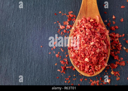 Getrocknete gehackte chili Pfeffer in der Löffel aus Holz. Ansicht von oben mit der Kopie Raum Stockfoto