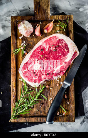 Rohes Fleisch, Rind oder Lamm Steak mit Knochen, zum Grillen, mit Gewürzen und Kräutern, Ansicht von oben Platz für Text Stockfoto