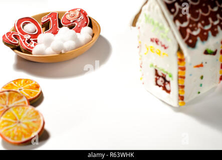 Weihnachtskarte: auf einer Holzplatte Es gibt rote Ingwer Cookies in der Form von Zahlen 2019 und Weiße runde Schneeflocken, neben dem Lügen Scheiben von o Stockfoto