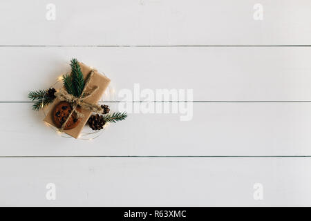 Weihnachten Geschenk eingerichtet: Tanne Zweige, Cookies, Pine Cone und Weihnachtsbeleuchtung. Stockfoto