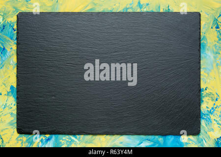 Texturierte schiefer Board für Gerichte auf bunten Hintergrund mit Kopie Raum Stockfoto