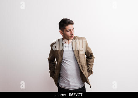 Eine selbstbewusste junge Hispanic Mann in einem Studio, Hände in den Taschen. Stockfoto