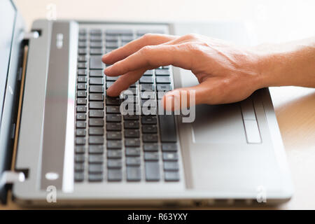 Männer Hand die Eingabe über die Tastatur des Laptops Stockfoto