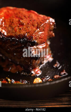 Saftiges Rindersteak und Kräuter Gewürze auf Gusseisen Skillet pan Stockfoto