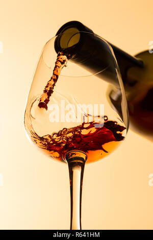 Ansicht von unten rot Wein aus der Flasche Wein zum Wein Glas gegossen wird, Stockfoto
