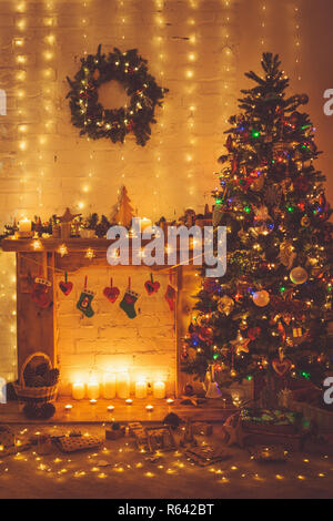 Schöne Weihnachten Hintergrund, dekoriert mit Kamin mit Massivholz Kaminsims, beleuchtete Weihnachtsbaum mit Kugeln und Ornamente, Sterne Stockfoto