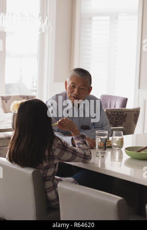 Großvater und Enkelin mit einander interagieren auf Esstisch Stockfoto