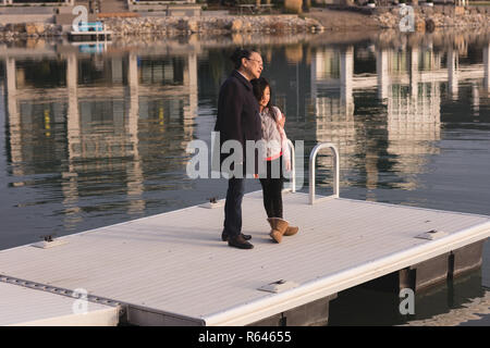 Großmutter und Enkelin auf Pier in der Nähe von Lake Side Stockfoto