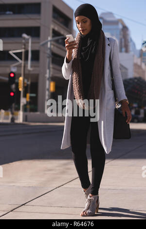 Hijab Frau mit Handy in der Stadt Stockfoto