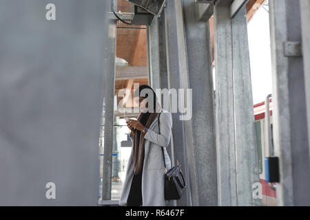 Frau mit Handy in der Plattform Stockfoto