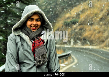 Junge indische Frau, die ihre ersten Schneefall im Winter genießen Urlaub in Kufri, Shimla, Himachal Pradesh. Stockfoto