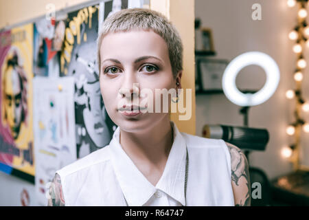 Attraktive Frau mit grünen großen Augen in ungewöhnlichen knabenhaften Haarschnitt Stockfoto