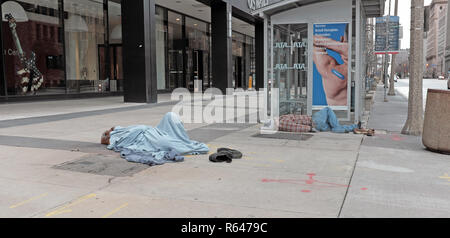 Zwei Männer schlafen auf dem Bürgersteig an der East 12. und Superior Avenue in der Innenstadt von Cleveland, Ohio während der 2018 Winter. Stockfoto