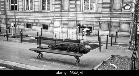 PARIS, Frankreich, 7. September 2018 - ein Mann schlafen auf einer hölzernen Bank in den Straßen von Paris, Frankreich. Stockfoto