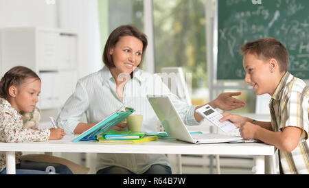 Kinder in der Schule in der Klasse mit Lehrer sitzen Stockfoto