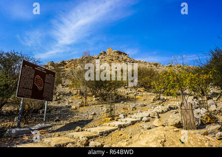 Ras Al Kaimah Dhayah Fort im Obergeschoss stehen auf dem Hügel mit malerischen Blauen bewölkten Himmel Hintergrund Stockfoto