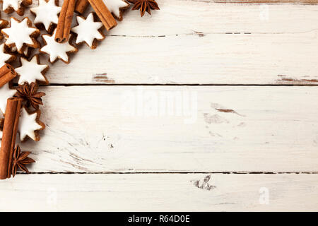 Hintergrund mit Zimt Federkiele, Sternanis und Star christmas Cookies auf rustikalem Holz geformt Stockfoto