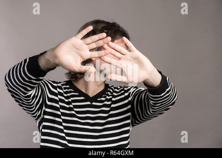 Ich gebe auf. Attraktiv unrasiert stilvollen Mann Palmen zeigt, demonstriert seine Unschuld, Rückkäufe, über grauer Hintergrund isoliert. Hübscher junger Mann Rai Stockfoto