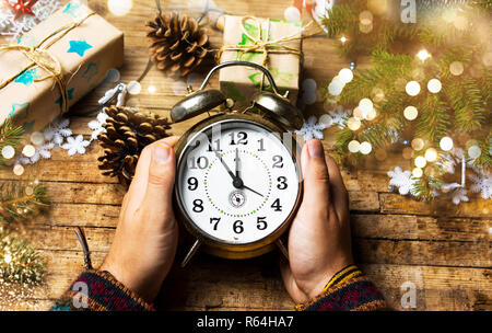 Person, die einen Vintage Uhr in festlicher Umgebung pov Stockfoto
