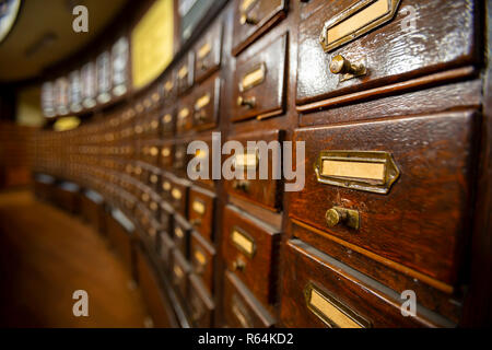 Holzschubkästen mit Metall Ornamente in einem altmodischen Bibliothek. Holzkisten mit Index Karten in der Bibliothek. Stockfoto