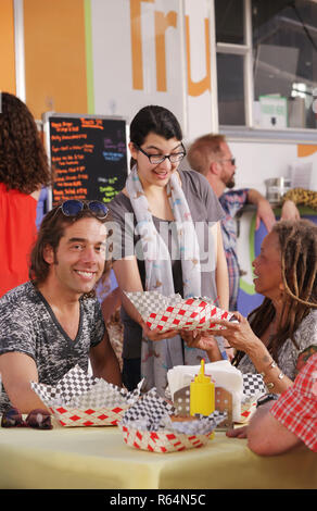Lächelt in die Kamera und wartet Mittagessen serviert. Stockfoto