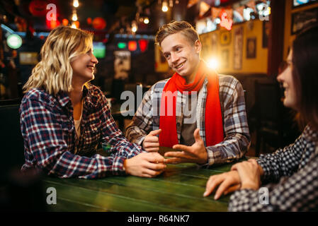 Jugendliche am Tisch sitzen in der Sports Bar. Fußball-Fans, Spiel TV-Ausstrahlung, junge Freunde Freizeiten im Pub Stockfoto