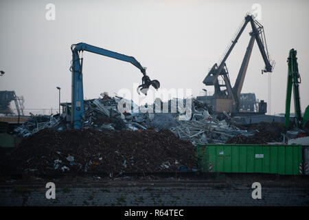 Ein Kran mit Greifer in Aktion auf Recyclinghof. Stockfoto