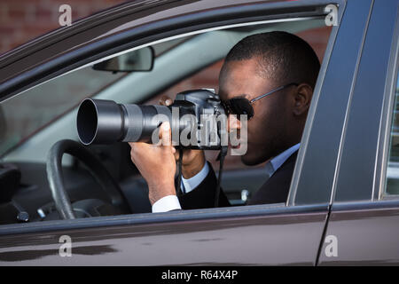 Detektiv Sitzen im Auto Fotografieren Stockfoto