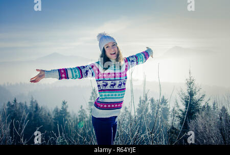 Glückliche junge Frau auf Karpaten Hintergrund in den Morgen. Mädchen bewundert Winterlandschaft mit geöffneten Armen Stockfoto