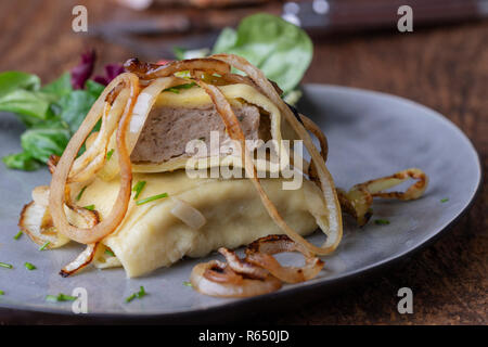 Schwäbische maultasche mit Zwiebeln auf einer Platte Stockfoto