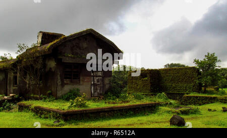 Abgebrochene haunted House mit grünem Laub Schimmel alle über Sie während der Monsunzeit grauer Himmel in Pune, Kerala, Indien Stockfoto