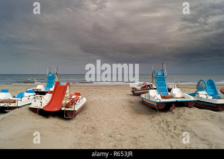 Strand mit farbenfrohen Tretboote und bewölkter Himmel Stockfoto