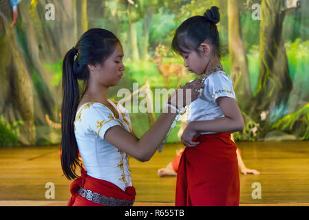 Phnom Penh, Kambodscha - Dezember 31, 2016: Ein älteres Mädchen helfen, eine jüngere Vorbereitung der Tanz Anzug in Champey Akademie der Kunst, eine gemeinnützige Schule Stockfoto