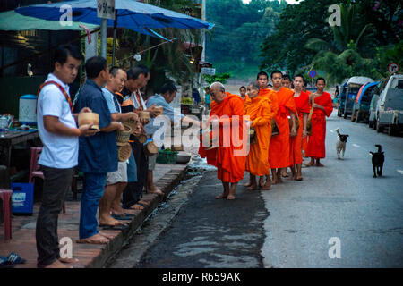 Tak Bat Ritual - Buddhistische Mönche erhalten Reis und Lebensmittel aus pupulation am frühen Morgen in Luang Prabang, Laos, Asien Stockfoto