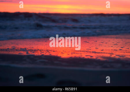 Lila Himmel bei Sonnenuntergang, lila und roten Schattierungen von Wasser und Himmel bei Sonnenaufgang Stockfoto