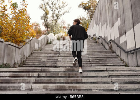 Sportlicher junger Mann läuft im Obergeschoss im Freien Stockfoto