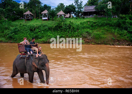 Eine touristische und mahout Fahrt einen Elefantenritt in Elephant Village Sanctuary Resort, in der Nähe von Luang Prabang Laos Stockfoto