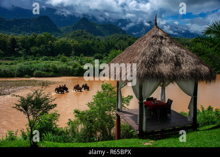 Eine touristische und mahout Fahrt einen Elefantenritt in Elephant Village Sanctuary Resort, in der Nähe von Luang Prabang Laos Stockfoto