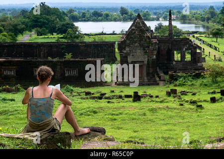 Touristische lesen Sie ein Buch in der Promenade, die zu den oberen Ebenen der Wat Phu Champasak Laos Stockfoto